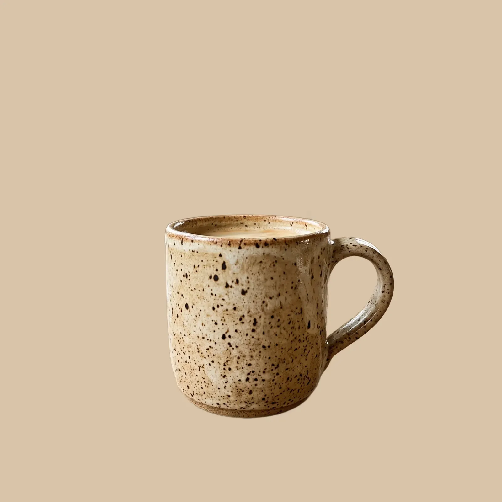 The same handmade mug on a warm wood-tone background